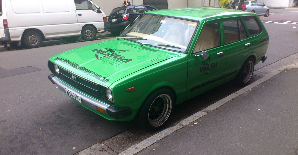 Eine Person in der Nähe einer Straße mit Fahrzeugen.