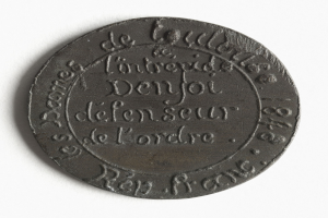 Schwarze Münze mit weißem Hintergrund, beschriftet mit Text, wahrscheinlich ein Token.