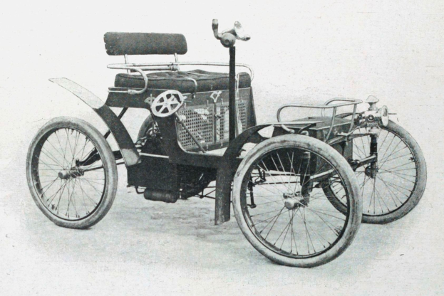 Vintage-Schwarz-Weiß-Foto eines frühen 1900er-Elektroautos mit schlankem, aerodynamischem Design, großem runden Scheinwerfer, geschwungener Dachlinie, vier großen Rädern und einem prominenten Heckmotor.