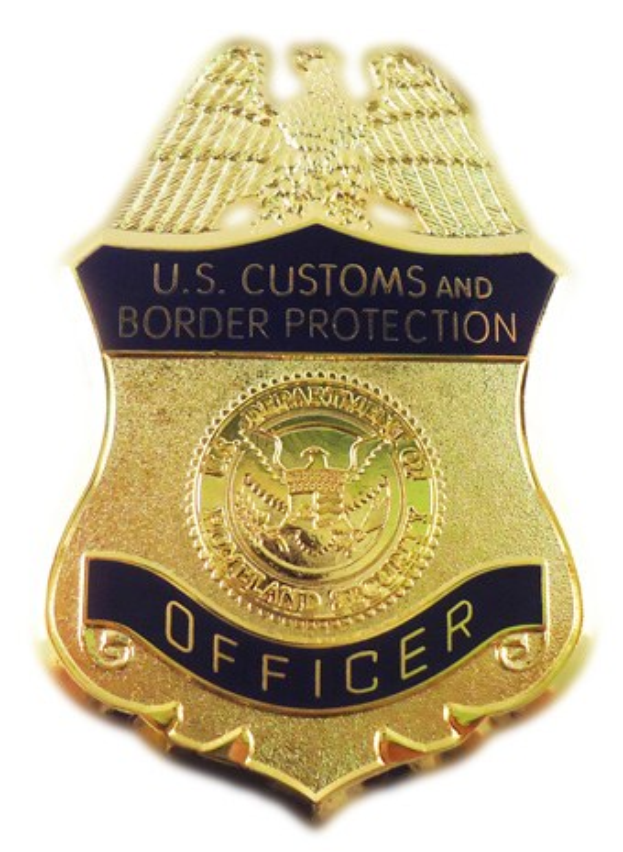 Goldene Abzeichen mit 'U.S. Customs and Border Protection Officer'-Text auf weißem Hintergrund.