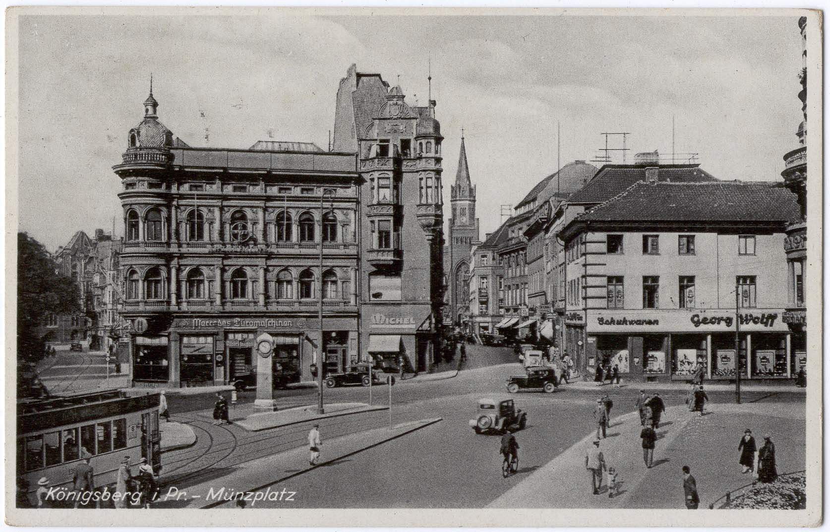 Schwarzes und weißes Foto einer belebten Münchner Stadtstraße mit Fußgängern, Fahrzeugen und Gebäuden an der Straße, Bäumen im Hintergrund und Text unten.