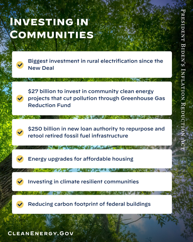 Plakat mit Baum- und Himmel-Hintergrund, das den Text 'Investing in Communities: Größte Investition in ländliche Elektrizität seit dem New Deal' zeigt.