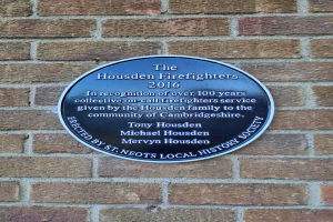 Rundes Schild an einem Backsteingebäude mit der Aufschrift "Housden Feuerwehr 2016".