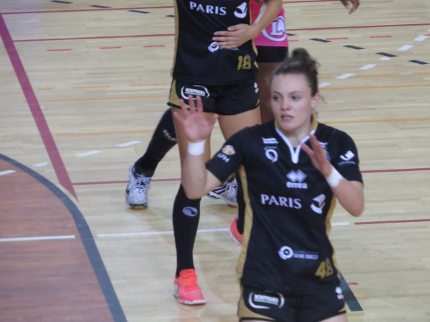 Eine Gruppe von Frauen in Sportuniformen spielt Volleyball auf einem Platz.