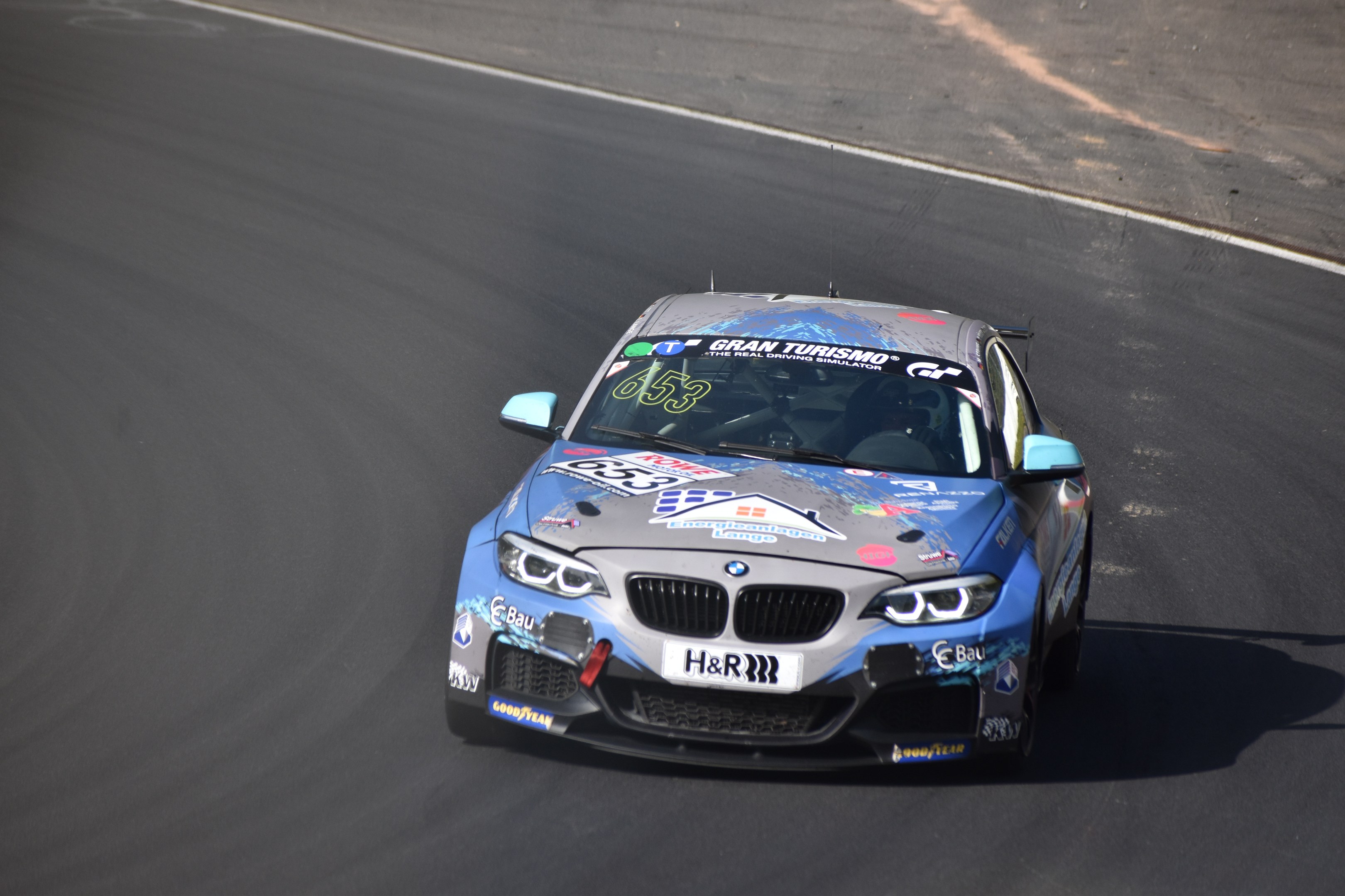 BMW M2 GT3 Rennauto auf einer Rennstrecke mit Text und Zahlen darauf.
