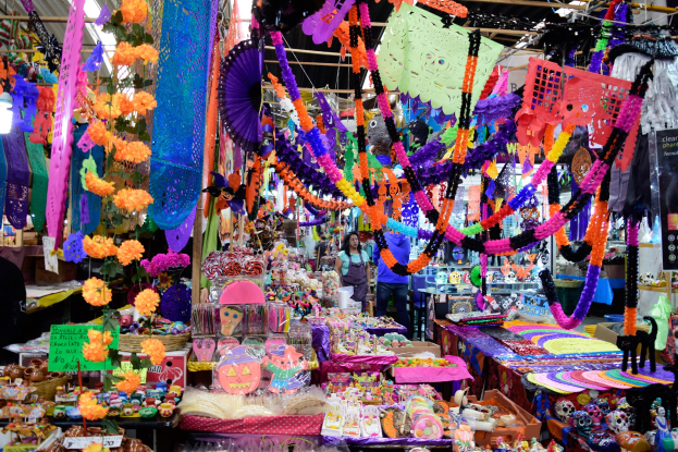 Ein belebter Markt mit Ständen, die Spielzeug, Dekorationsgegenstände und andere Gegenstände verkaufen, Menschen, die durch die Gänge schlendern, und Deckenbeleuchtung.