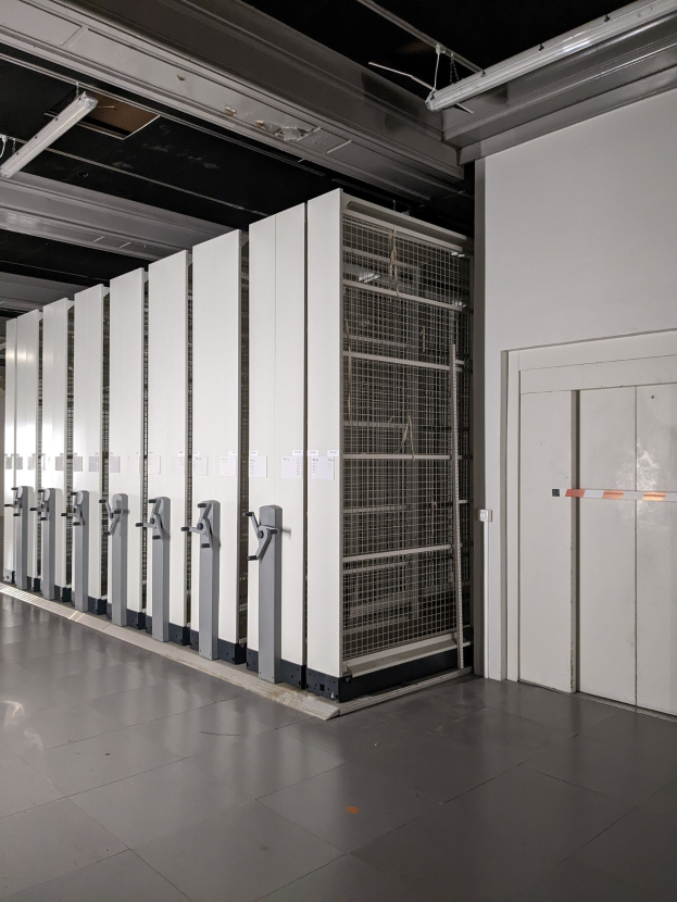 Großer Raum voller numerous Server, mit einem Boden, einer rechten Wand und einer Decke mit Beleuchtung, was auf ein Rechenzentrum hinweist.