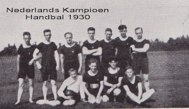 Schwarzes und weißes Foto einer Handballmannschaft aus dem Jahr 1930, mit einigen Mitgliedern im Vordergrund stehend und sitzend, Bäumen und einem klaren Himmel im Hintergrund und Text oben.
