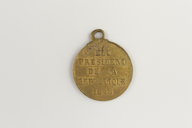 Goldmedaille mit der Aufschrift "Präsident der Republik" auf weißem Hintergrund.