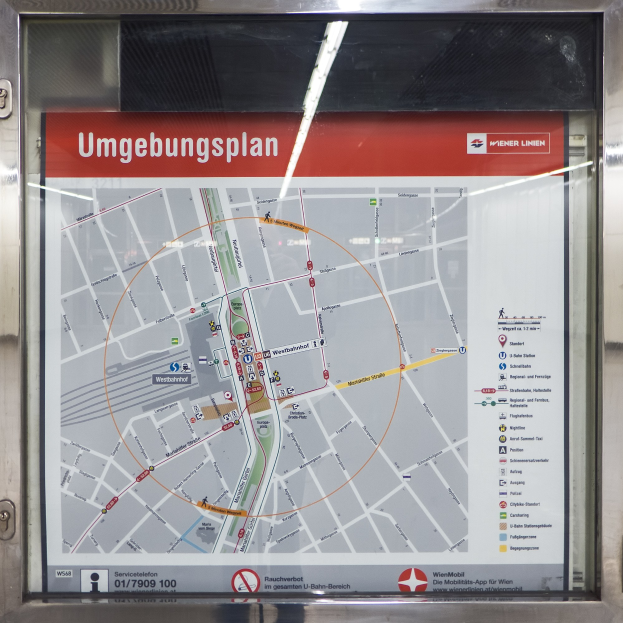 Ein detaillierter U-Bahn-Halteplan von München, Deutschland, der auf einer Glasplatte angezeigt wird und einen umfassenden Überblick über die Stadt bietet.