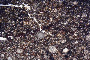 Nahaufnahme einer gesprungenen, schmutzigen Straße mit einer rauen, unebenen Oberfläche.