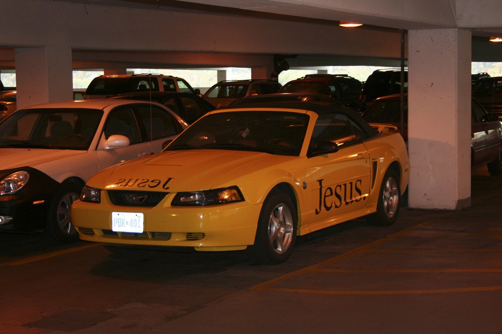 Ein überfüllter Parkplatz vor einem Gebäude mit zahlreichen geparkten Autos.