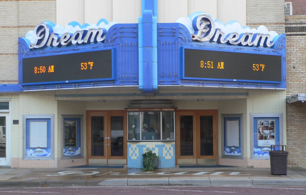 Außenansicht des Dream Theaters in St. Louis, Missouri, mit Glastüren und -fenstern, einem Namen Schild, einem Müllbehälter, einem Topf mit einer Pflanze und einer Straße am Boden.