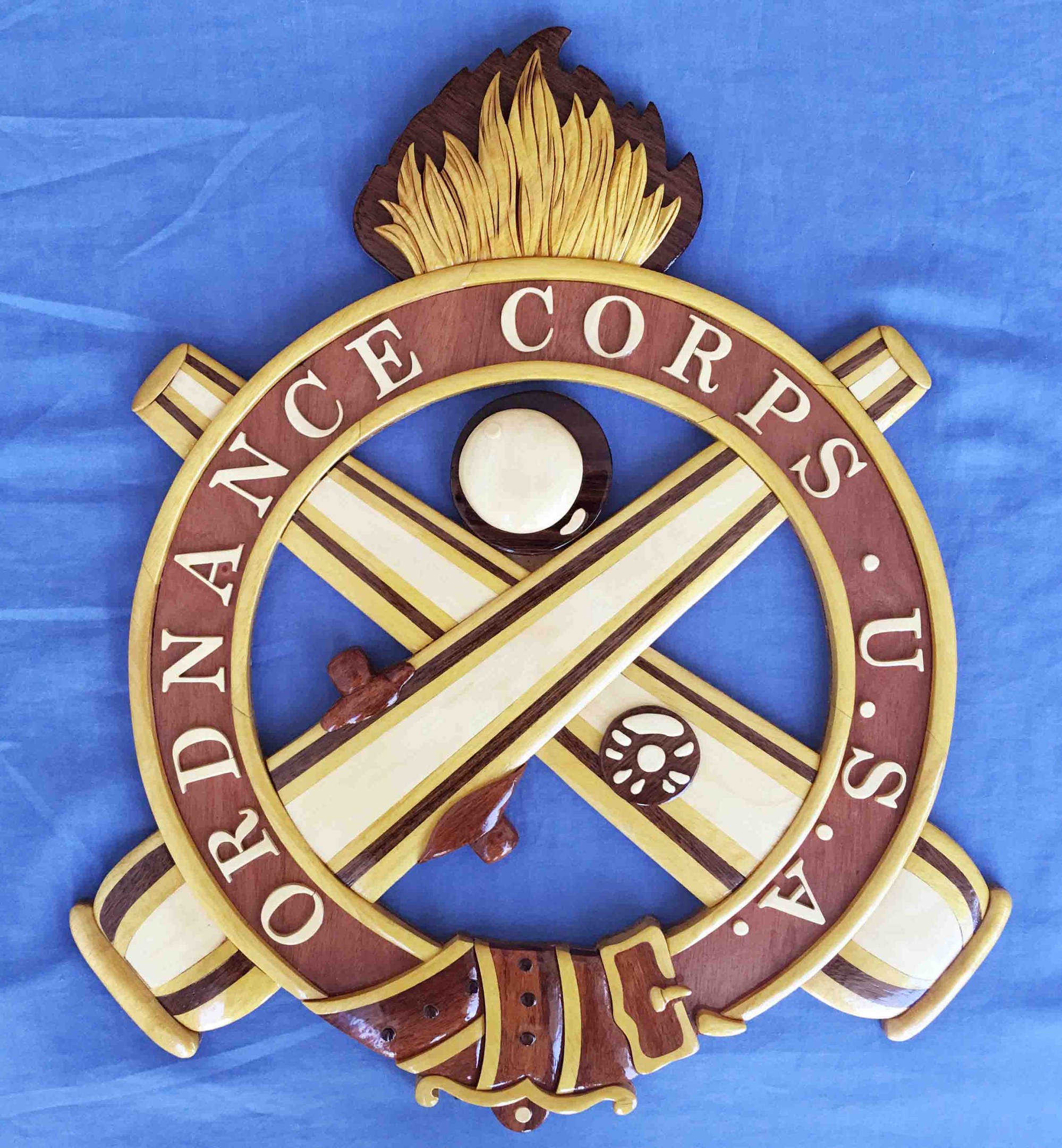 Holzschild mit "Ordnance Corps"-Text, verziert mit einem geschnitzten weißen Stern auf einem navyblauen Hintergrund mit goldener Umrandung, auf blauem Stoff montiert.